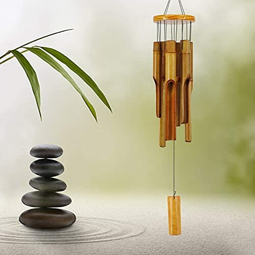 Bamboo wind chime next to stacked stones.