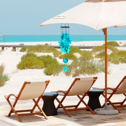 Beachfront lounge chairs under an umbrella with blue decorations.