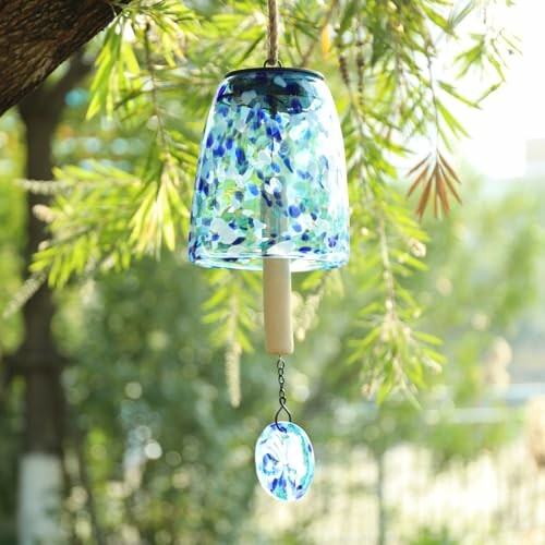 Blue glass wind chime hanging from a tree branch