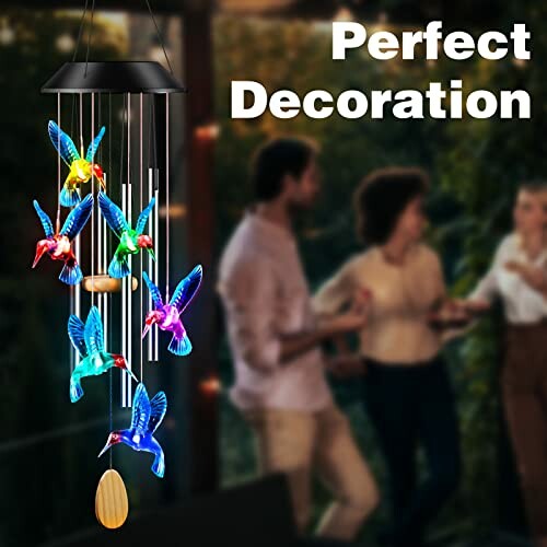 Colorful bird wind chime with people in background.