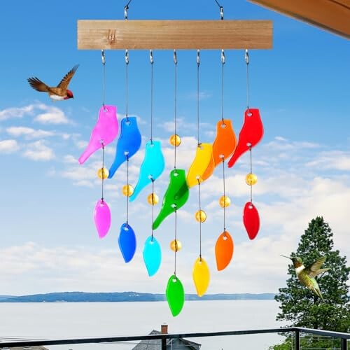 Colorful bird-shaped wind chime with hummingbirds in the background