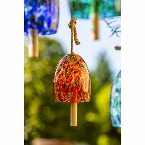 Colorful glass wind chime with a wooden clapper hanging outdoors.