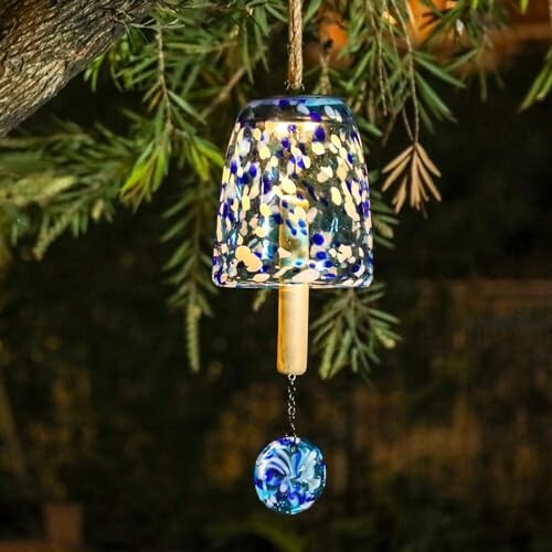 Colorful glass wind chime hanging from a tree branch