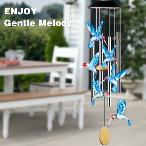 Hummingbird-themed wind chimes with table in background.