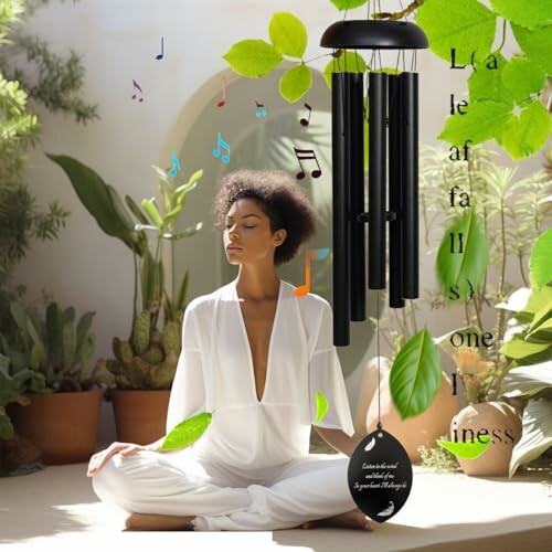 Woman meditating with wind chimes and plants