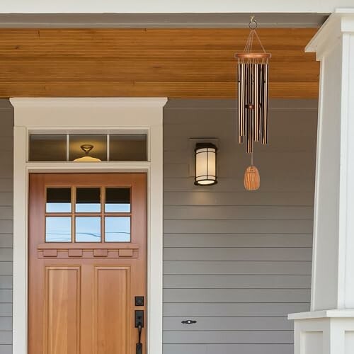 Modern front porch with wooden door and wind chime