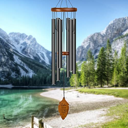 Wind chimes hanging in front of a mountain lake scenery.